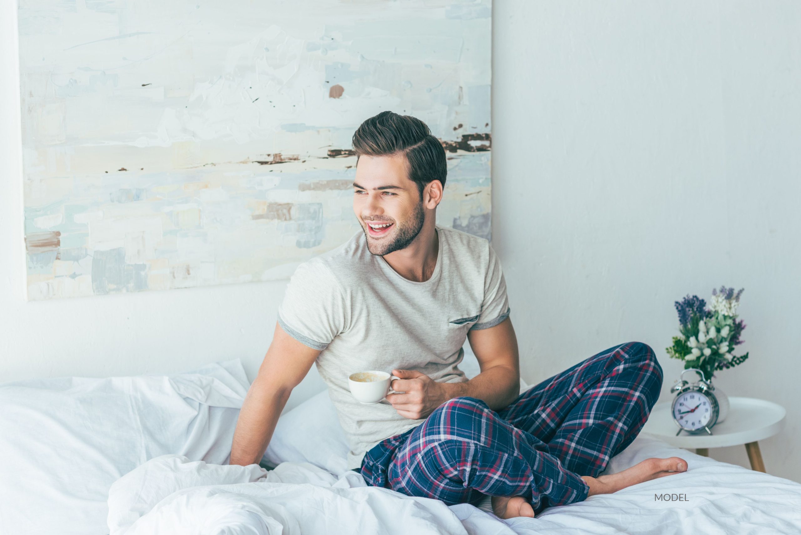 Man sitting on bed in his pajamas