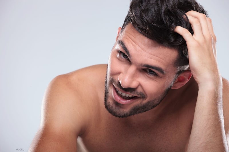 Attractive man moving hands through full head of hair