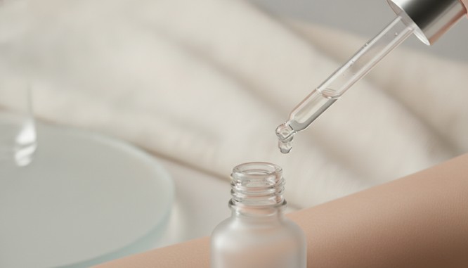 Color photograph of a dropper bottle of serum against bare skin. Hyaluronic acid serum guidance from Frank Agullo, MD, FACS, at Southwest Plastic Surgery in El Paso.